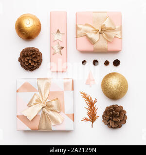 Pink and gold christmas gifts isolated on white background. Wrapped xmas boxes, christmas ornaments, baubles and pine cones. Christmas composition. Stock Photo