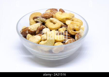 A small glass bowl of roasted and salted mixed nuts. Stock Photo