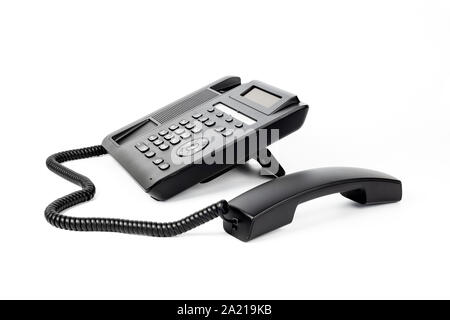 One black IP phone with a lifted handset, on a white background, close-up Stock Photo
