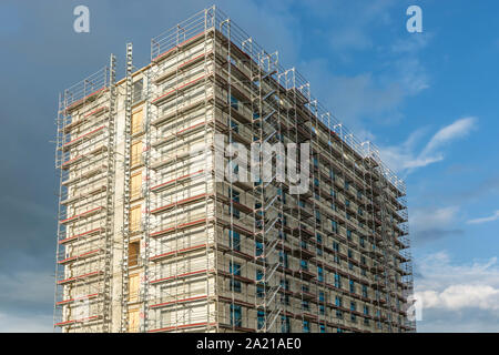 Construction of a skyscraper with scaffolding on the facade Stock Photo