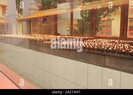 Series of small oil lamps in a  Tibetan Buddhist Monastery temple at Sikkim, India Stock Photo