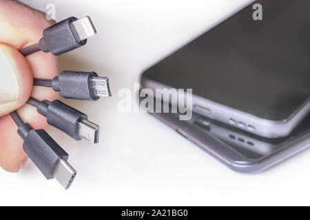 Various charging cables with mobile phones Stock Photo
