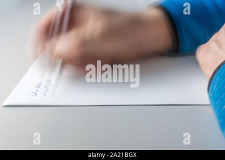 Man writes letter to his partner with the words in German "Hello darling, I do not know ..." Stock Photo