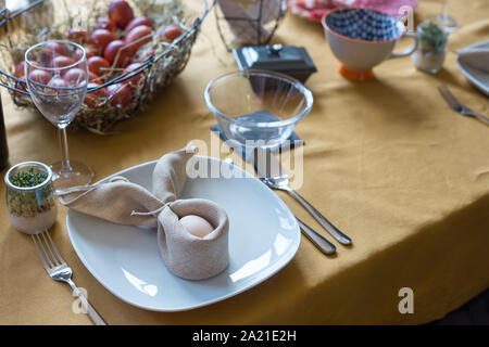 Real family table set for Easter breakfast in traditional Polish home. Basket filled with eggs colored with onion skins. Stock Photo