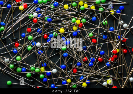A bunch of multi colored round head pins on a black background Stock Photo