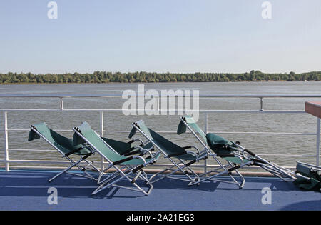 Camping folding chairs on the deck of the Danube River cruise ship on the Danube River near Belgrade. Stock Photo