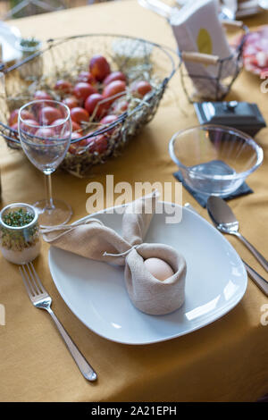 Real family table set for Easter breakfast in traditional Polish home. Basket filled with eggs colored with onion skins. Stock Photo