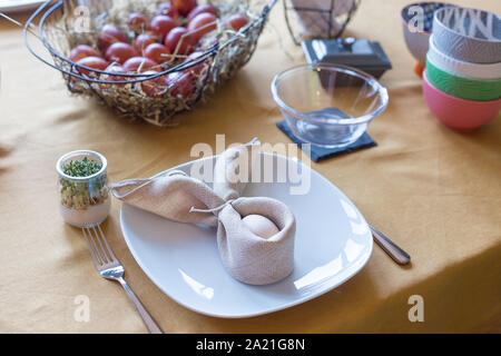 Real family table set for Easter breakfast in traditional Polish home. Basket filled with eggs colored with onion skins. Stock Photo
