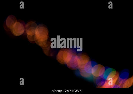Abstract blur multicolor orange,blue, purple city or street light bokeh isolated on black background with copy space. Stock Photo