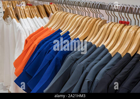 Multicolored t-shirts on hang for sale in shop Stock Photo