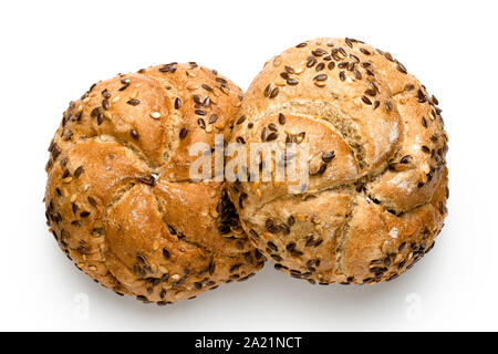 Two traditional whole wheat kaiser rolls with linseeds and sesame seeds isolated on white. Top view. Stock Photo