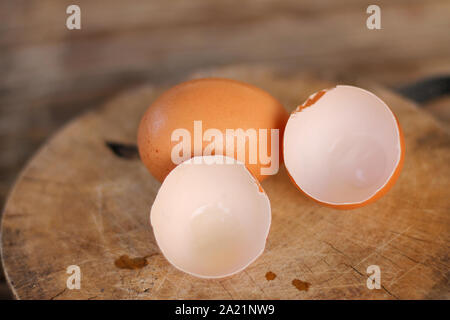 Brown eggs with eggshells on a wooden chopping board On the bamboo battens. Stock Photo