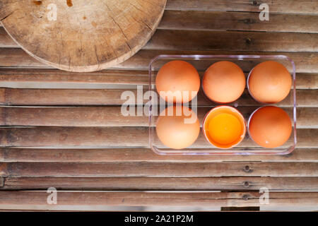 Viewed from above, one of the six broken eggs on a bamboo floor. Stock Photo