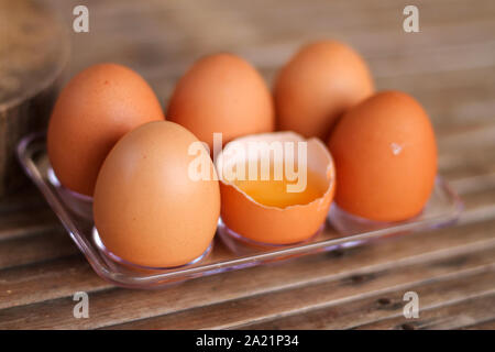 One of the six broken eggs on the bamboo floor. Stock Photo