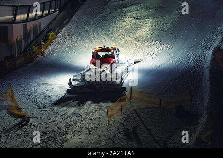 Snowcat ratrack machine making night show performance on snow piste hill at alpine skiing resort Ischgl in Austria Stock Photo