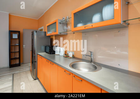 Stylish orange kitchen set. Home appliances. Stock Photo
