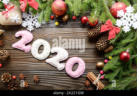 Colorful stitched digits 2020 of polkadot fabric with Christmas decorations flat lay on wooden background Stock Photo