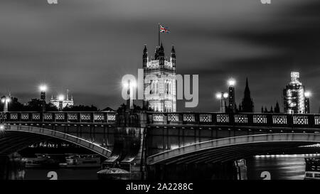 B & W with coloured flag concept image. Light trails across Lambeth Bridge over the River Thames in London. Taken on tripod & 1 minute slow exposure Stock Photo