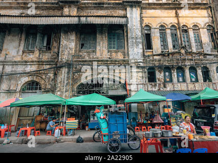 Yangon, Myanmar - Street food sellers in front of old ruined building at Yangon, Burma Stock Photo