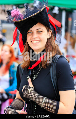 Pirate Day in Hastings, UK. Close up of pretty Caucasian young woman, dressed in black as pirate and smiling at viewer. Wears small nose ring. Stock Photo