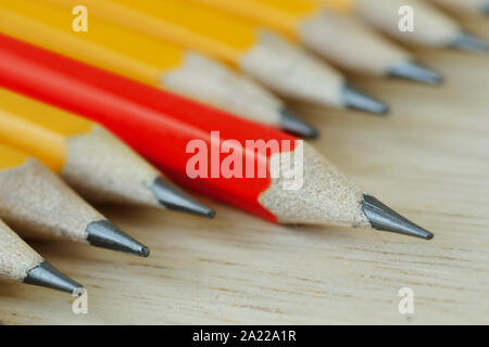 Red pencil standing out from croud of yellow pencils - Think different and leadership concept Stock Photo