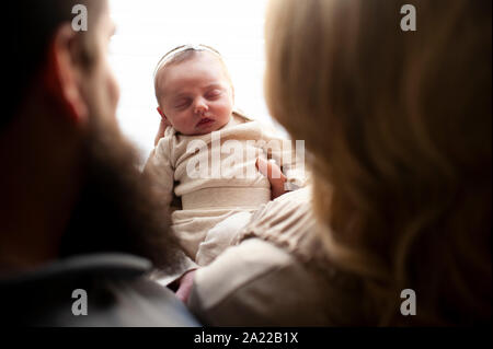 Downward view between mother and father of newborn baby girl sleeping Stock Photo