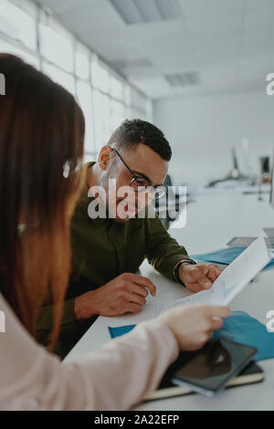 Businesswoman and businessman having a discussion with new project success financial statistics at work place - two business people talking Stock Photo