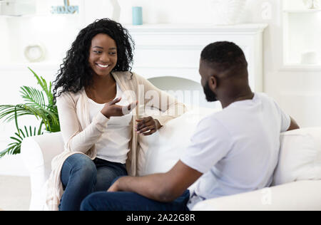 Pleasant conversation. Young husband and wife chatting together in living room at home. Stock Photo