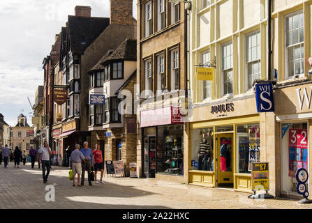 Shops in old buildings on pedestrianised shopping street in historic town centre. High Street, Stamford, Lincolnshire, England, UK, Britain Stock Photo