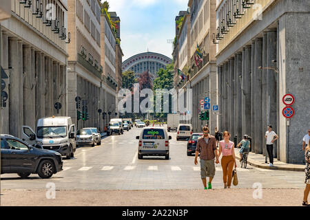 A couple walking along Via Roma ,an elegant street with baraque colonnaded  arcades in Turin , Italy with Porta Nuova railway station in the distance Stock Photo