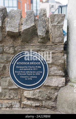 Circular blue information plaque fixed to a wall on the Windsor side of Windsor Bridge