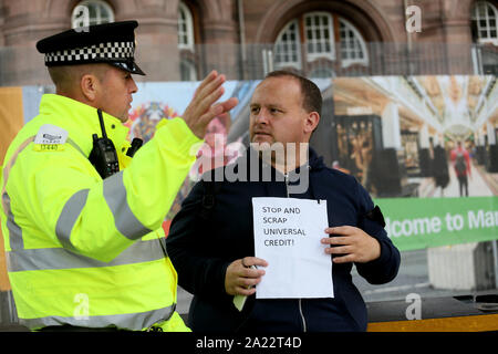 Manchester, UK. 30th September,2019. Protests and theatre outside the Tory Party Conference where a Police officer requests that a demonstrator moves to an area set aside for protest.  The protester refused and remained at a spot close to the Tory party conference. Manchester, Lancashire, UK. Credit: Barbara Cook/Alamy Live News