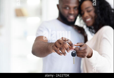 Ownership concept. Young African American couple showing keys to their home, selective focus on hands Stock Photo