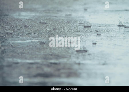 rain drops falling on a street Stock Photo