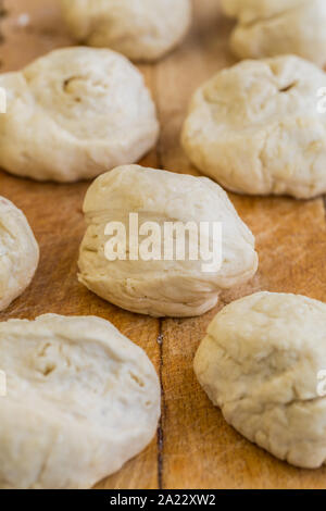 Fresh raw yeast dough buns on cutting board Stock Photo