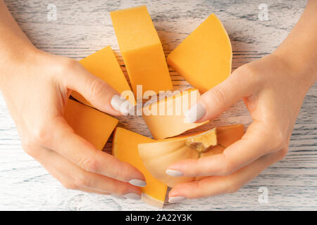 The girl rakes in two hands pieces of fresh ripe pumpkin. The concept of a vegetable natural diet Stock Photo