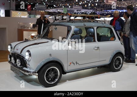 White small vintage car from car brand Mini Austin with skis on the roof and some viewer at exhibition Autosalon Genf 2019 in Geneva, Switzerland Stock Photo