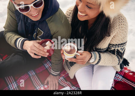 Group of millenial young adult friends enjoying wintertime and in a snow filled park Stock Photo