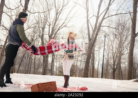 Group of millenial young adult friends enjoying wintertime and in a snow filled park Stock Photo