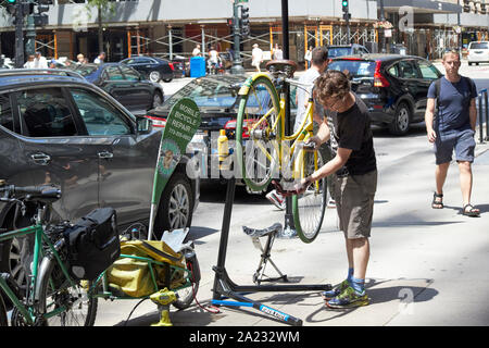 man with mobile bicycle repair business repairing bike on city sidewalk street chicago illinois united states of america Stock Photo