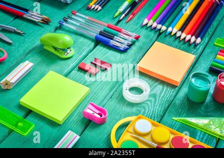 Creative school concept. Arranged school accessories on a green desk. Stock Photo