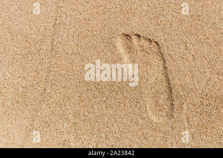 Right foot print in yellow sand. top view. Stock Photo