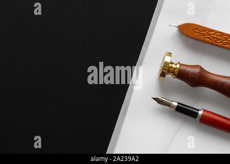 Notary public wax stamper. White envelope with brown wax seal, golden stamp. Responsive design mockup, flat lay. Still life with postal accessories