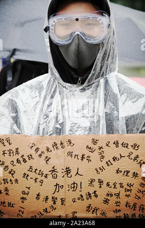 Hong Kong protester wearing face mask and goggles with placard seen September 2019 Stock Photo