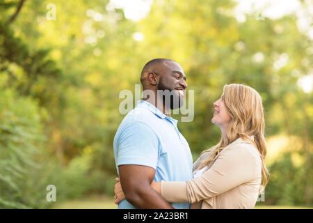 Loving mixed race couple hugging and laughing. Stock Photo