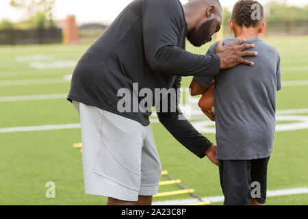 American Football coach training a young athlete. Stock Photo