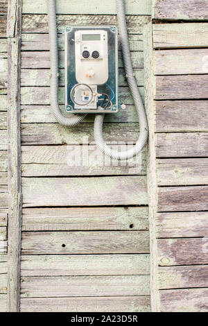 Modern electrical meter hanging on the old wooden house in the village outdoors Stock Photo