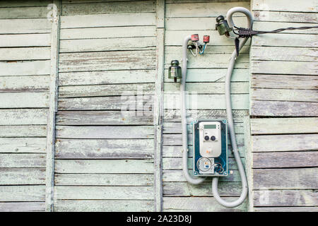 Modern electrical meter hanging on the old wooden house in the village outdoors Stock Photo