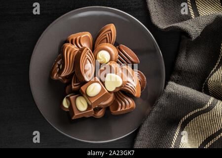 Various chocolate pralines on plate. Top view. Stock Photo