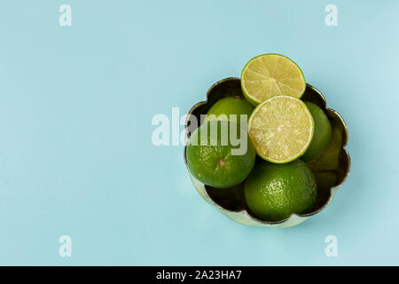 Freshly lime fruits on trendy light blue background Stock Photo